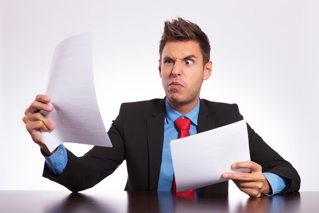 young business man at the table reading something unbelievable a